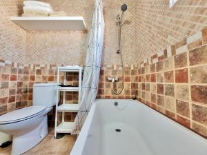łazienka z białą wanną i toaletą w obiekcie CristianPlaya Attic w mieście Los Cristianos +37 zdjęć