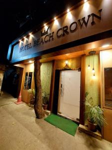 un hotel con una puerta blanca y un árbol fuera en Hotel Beach Crown Juhu, en Bombay