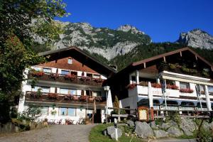ein Gebäude mit Blumen auf den Balkonen und einem Berg in der Unterkunft Gasthaus-Pension Seeklause in Ramsau bei Berchtesgaden