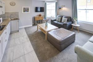 ウィットビーにあるHost & Stay - The Runswick at Brunswick Holiday Apartmentsのソファとテーブルのあるキッチンとリビングルーム