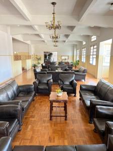 a large waiting room with leather couches and a table at Apartamento aconchegante em condomínio encantador. in Lambari