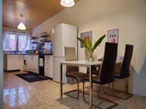eine Küche mit einem Tisch und Stühlen sowie einem Kühlschrank in der Unterkunft Stunning 1-Bed House in Tema- Oheneba villa in Tema