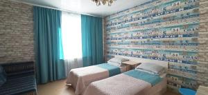 two beds in a room with a wall with writing on it at Rent Rooms Barracuda in Khabarovsk