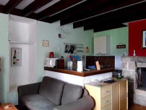 ein Wohnzimmer mit Couch und Küche in der Unterkunft Ker Jerome - Traditional Stone Breton Cottage near to Dinan in Trélivan