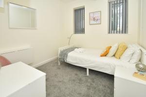 a white room with a bed and a mirror at Townhouse @ Hall O Shaw Street Crewe in Crewe