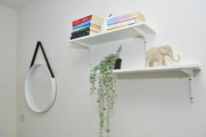 a white shelf with a mirror and books at Townhouse @ Hall O Shaw Street Crewe in Crewe