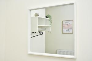 un miroir dans une chambre blanche avec une étagère dans l'établissement Townhouse @ Hall O Shaw Street Crewe, à Crewe