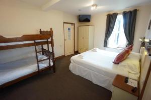 a bedroom with two bunk beds and a window at Church Hill House in Betws-y-coed