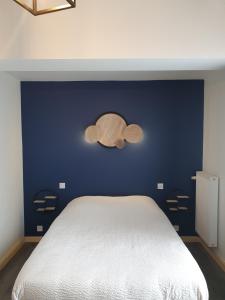 1 dormitorio con una pared azul y 1 cama en HOTEL DU GRAND LAC en Laffrey