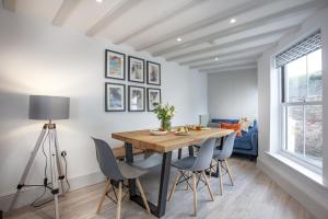 a dining room with a wooden table and chairs at Birdcage Cottage, Kingsand in Kingsand