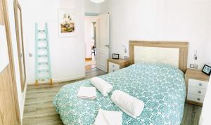 1 dormitorio con 1 cama grande con manta azul y blanca en SoKa Be@ch House, en Tarifa