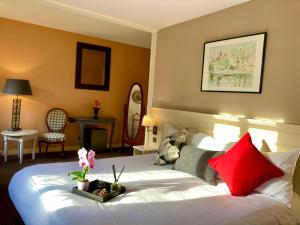 una habitación de hotel con una cama grande con almohadas rojas en Château Corneille, en Vieux-Villez