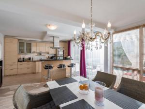 a dining room with a table with chairs and a chandelier at Landhaus Central in Söll