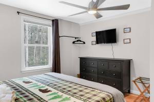 um quarto com uma cama, uma ventoinha de tecto e uma televisão em Cardinals Perch em Campton