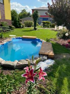 a small pool with a wooden bridge and a flower at Pokoje Hotelowe Siedlczanka in Siedlce