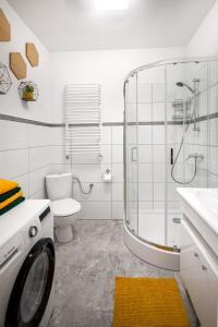 a white bathroom with a washing machine in it at Apartament Miodownik in Międzylesie +25 photos