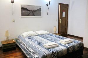 a bedroom with a bed with two pillows on it at Manawa Camp in Costa da Caparica
