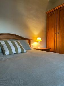 een slaapkamer met een bed en een lamp op een tafel bij La Figuera in Vilafames