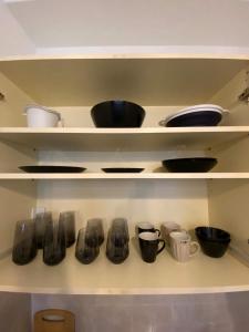 a shelf with bowls and utensils on it at cozy apartment in Volos