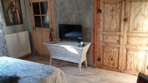 a bedroom with a tv on a dresser with a bed at la maison porte bonheur in Chantelle