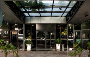 an office building with glass doors and potted plants at Manhattan Porto Alegre by Mercure in Porto Alegre