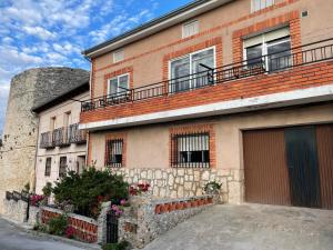 un edificio de ladrillo con 2 balcones en la parte superior. en Casa Daniela, en Fuentidueña