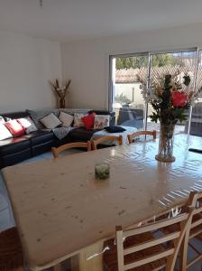 ein Wohnzimmer mit einem Tisch und einem Sofa in der Unterkunft Maison entière in Chorges