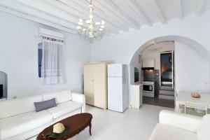 een witte woonkamer met een witte bank en een tafel bij Thomas Traditional House in Chora in Amorgós