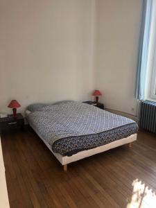 a bed in a room with two lamps on tables at Appartement de charme avec parking et terrasse in Besançon