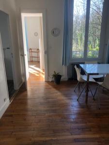 a room with a table and chairs and a wooden floor at Appartement de charme avec parking et terrasse in Besançon