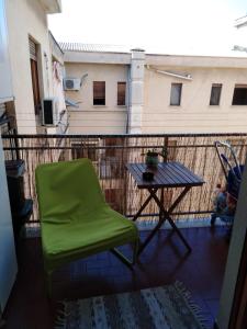 a green chair and a table on a balcony at Magione Apartment&Rooms in Palermo