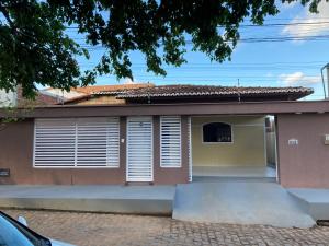 een huis met witte luiken erop bij casa em Barra de Cunhaú-RN in Barra do Cunhau
