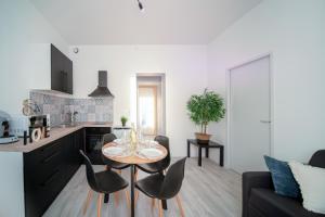 a kitchen and a living room with a table and chairs at Appartement Cosy Bressan in Bourg-en-Bresse