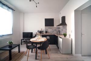 a kitchen and dining room with a table and chairs at Appartement Cosy Bressan in Bourg-en-Bresse
