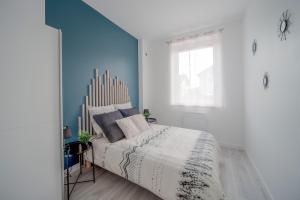 um quarto com uma cama com uma parede azul em Appartement Cosy Bressan em Bourg-en-Bresse