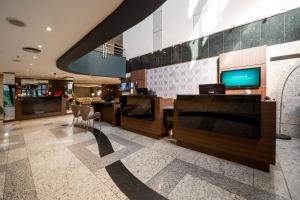 a living room filled with furniture and a tv at Manhattan Porto Alegre by Mercure in Porto Alegre