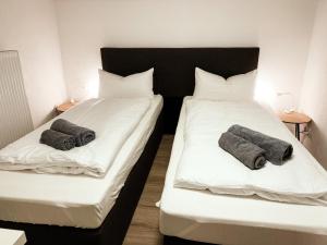 two beds in a room with towels on them at Sali-Bayreuth direkt am Tierpark in Bayreuth