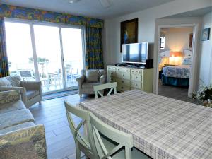 Sala de estar con mesa, cama y TV en 4th Floor 3 BR Resort Condo Direct Oceanfront Wyndham Ocean Walk Resort Daytona Beach 411, en Daytona Beach