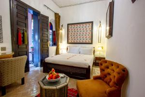 ein Hotelzimmer mit einem Bett und einer Obstschale auf dem Tisch in der Unterkunft Dar Anika in Marrakesch