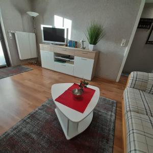 ein Wohnzimmer mit einem Tisch und einem roten Handtuch darauf in der Unterkunft Ferienwohnung Greschke in Prerow