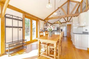 a kitchen with a wooden table and a dining room at Amber Lodge in Ashover