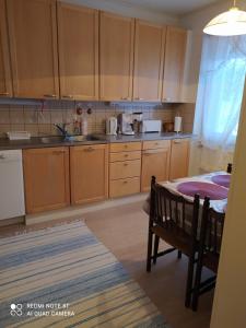 Una cocina con gabinetes de madera y una mesa en ella. en Korento, en Sotkajärvi