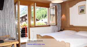 Schlafzimmer mit einem Bett und einem Fenster in der Unterkunft Hotel Restaurant Mattmarkblick in Saas-Almagell