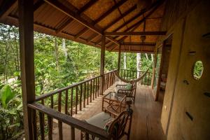 un porche de una casa con 2 sillas y una hamaca en Chirapa Manta Amazon Lodge, en Lamas