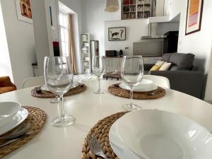 a table with wine glasses and plates on it at No 5 Cádiz in Cádiz