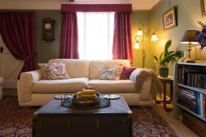 a living room with a couch and a coffee table at Romney, a cosy Victorian cottage in a picturesque Suffolk village in Cavendish