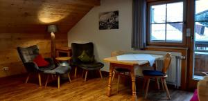 ein Esszimmer mit Stühlen, einem Tisch und einem Fenster in der Unterkunft Biobauernhof Vilshof in Tannheim