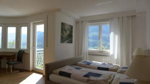a bedroom with a bed and a desk and windows at Appartement Trafoier in Tirolo +52 photos
