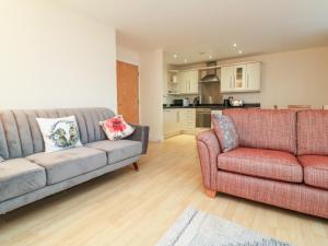 sala de estar con 2 sofás y cocina en 1 Tregonwell Court, en Minehead