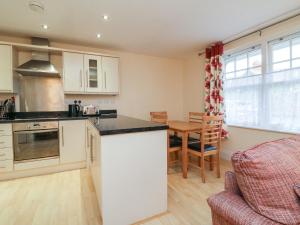 a kitchen and living room with a table and chairs at 1 Tregonwell Court in Minehead